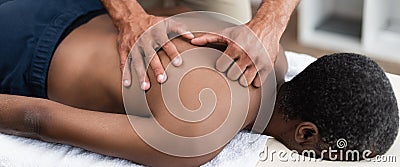 chiropractor doing back massage to african Stock Photo