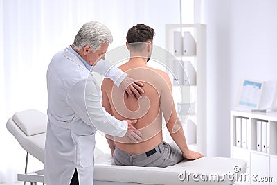 Chiropractor examining patient with back pain Stock Photo