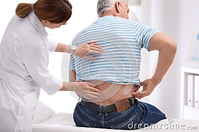 Chiropractor examining patient with back pain Stock Photo