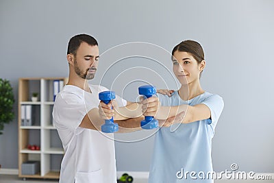 Chiropractor or osteopath fixing woman patient with dumbbels in right position for pain relief Stock Photo