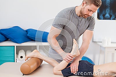 Chiropractor stretching boy's leg Stock Photo