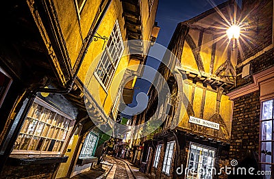 A Chirstmas night view of Shambles, a historic street in York featuring preserved medieval timber-framed buildings with jettied Editorial Stock Photo