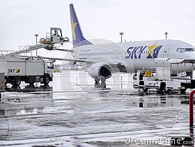 Airplane cleaner service washing mud and snow from SKY airline`s aircraft Editorial Stock Photo