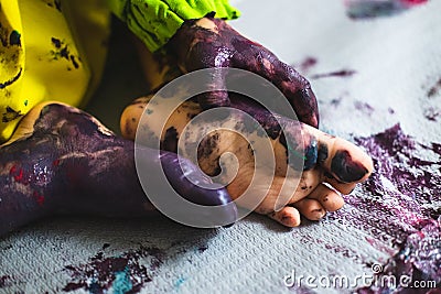 Little kid hands and feet covered with multiple colours Stock Photo