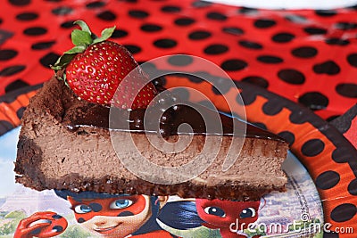 chocolade cake with strawbery on the flybug and cat plate Stock Photo