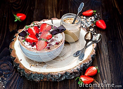 Chocolate almond butter maca smoothie bowl topped with sliced strawberries, chopped chocolate and pomegranate seeds Stock Photo