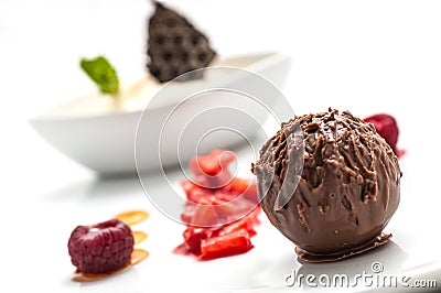 Chocolate ball with ice cream and fruit on white plate, sweet dessert with chocolate, product photography for patisserie or restau Stock Photo