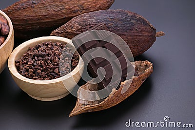 Chocolate bar and dried cocoa pod, cocoa nibs in wooden bowl on Stock Photo