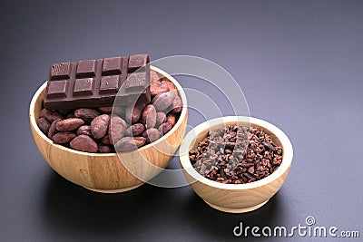 Chocolate bar and dried cocoa seed, cocoa nibs in wooden bowl on Stock Photo