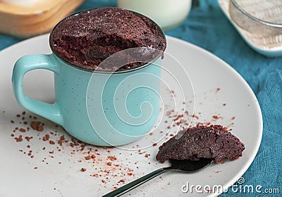 Chocolate biscuit cake in a blue ceramic mug, microwave baking. muffin Stock Photo