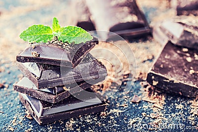 Chocolate. Black chocolate. A few cubes of black chocolate with mint leaves. Stock Photo