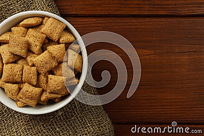 Chocolate breakfast pads in a white bowl on burlap on a dark table. Top view Stock Photo