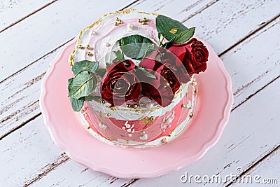 Chocolate cake covered with Swiss meringue buttercream, with three red flowers on top Stock Photo