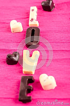 Chocolate candies in black and white, the heart and the word love Stock Photo