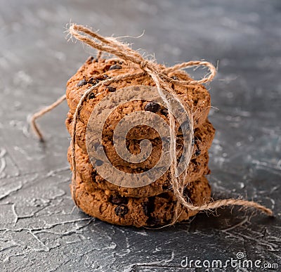 Chocolate chip cookies stacked and tied with a cord on a textured background Stock Photo