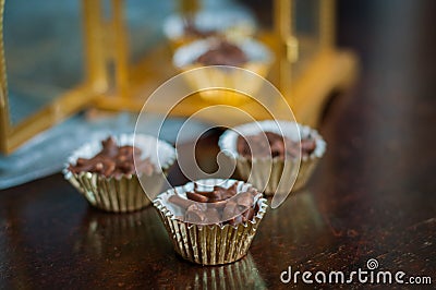 Chocolate Covered Almonds in golden paper cups. Stock Photo