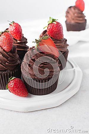 Chocolate cupcake with dark chocolate buttercream and strawberries, double chocolate cupcakes with american buttercream Stock Photo