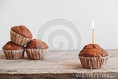 Chocolate cupcakes with candle on wooden table. Copy, empty space for text Stock Photo