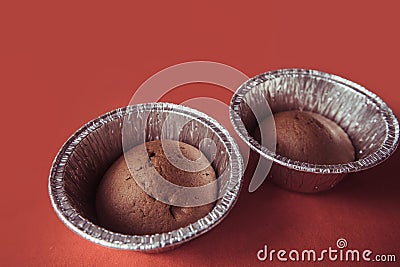 Chocolate cupcakes in foil baking dish on Marsala background. Brown muffins in foiled baking forms Stock Photo