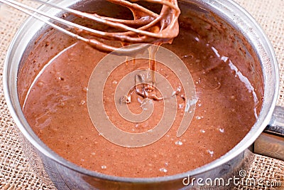 Chocolate dough. Hand mixing brownie`s ingredients in the bowl. Chocolate cake cooking. Stock Photo