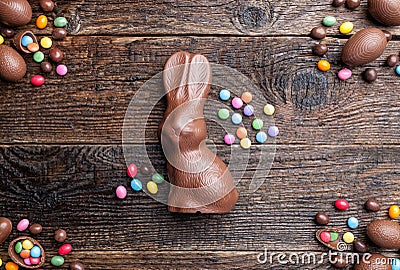 Chocolate Easter bunny, eggs and sweets on rustic background Stock Photo