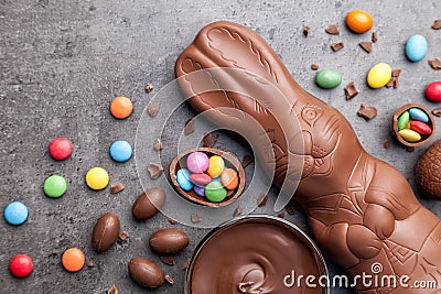 Chocolate Easter bunny, eggs and sweets on rustic background Stock Photo