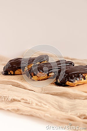 Chocolate eclair on wooden desk food photography. Bekery, cake , choco, pie, confectionary, cream. Three fresh eclairs with chocol Stock Photo