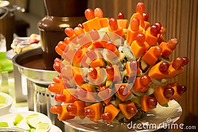 Chocolate fountain and mixed fruit skewer Stock Photo