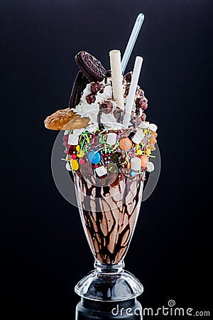 Chocolate freak shakes in a beautiful glass isolated on black background. Close-up. Space for text Stock Photo