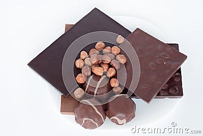 Chocolate, hazelnut and chocolate marshmallow are lying on a white plate. Nutritious food. Stock Photo