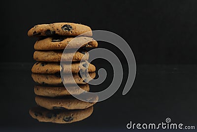 Chocolate homemade holiday cookies with chocolate drops are stacked on top of each other with a reflection side view of copy space Stock Photo