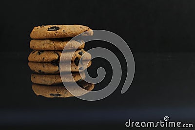 Chocolate homemade holiday cookies with chocolate drops are stacked on top of each other with a reflection side view of copy space Stock Photo
