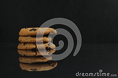 Chocolate homemade holiday cookies with chocolate drops are stacked on top of each other with a reflection side view of copy space Stock Photo