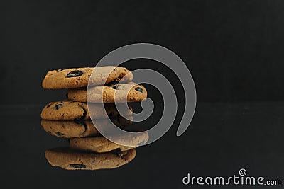 Chocolate homemade holiday cookies with chocolate drops are stacked on top of each other with a reflection side view of copy space Stock Photo