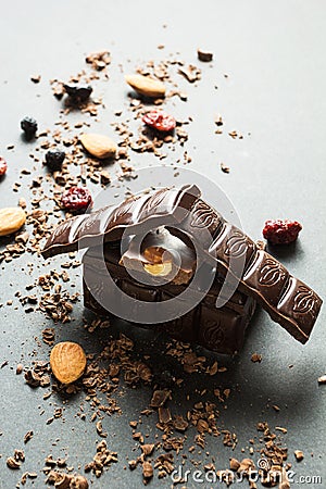 Chocolate house and dried berries with nuts on a black background, vertically Stock Photo