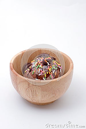 Chocolate ice cream with colorful toping in wood bowl isolated. Stock Photo