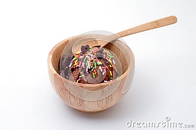 Chocolate ice cream with colorful toping in wood bowl isolated. Stock Photo