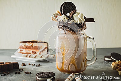 Chocolate milkshake with dripping sauce, cream, cocoa cookies and cake Stock Photo