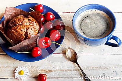 Chocolate muffin with cherries on the plate. A Cup of coffee. Stock Photo