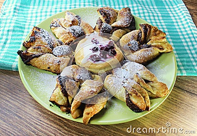 Chocolate nugget puff pastry flower with the vanilla sauce and sour cherry covered with powdered sugar Stock Photo