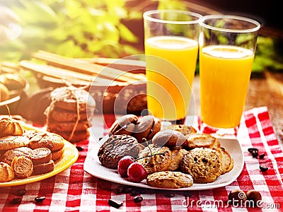 Chocolate cookies, sand heart shape cake with orange juice outdoor Stock Photo