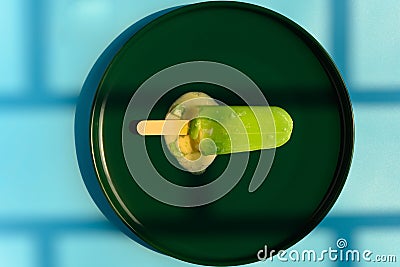 a chocolate outer with durian filling popsicle starts melting in the shadow of a window Stock Photo