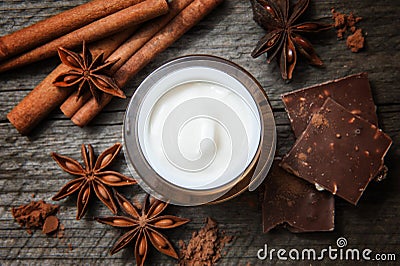 Chocolate skin treatment. Cosmetic jar with lotion, cocoa, anise, cinnamon sticks. Stock Photo