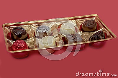 Chocolates in gold packaging on a red background Stock Photo