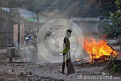 Chon Buri, Thailand - 16 February: Cambodian workers stand to watch for fires when they burn and destroy waste in the work area on Editorial Stock Photo