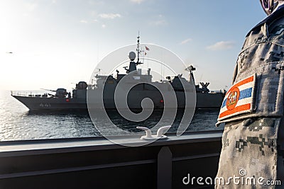 Notable Royal Thai Navy ensign flag fabric badge over the grey-color digital camouflage sleeve of sailor with H.T.M.S. Editorial Stock Photo