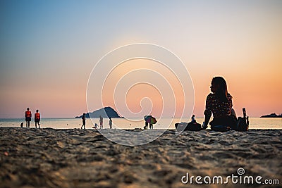 CHONBURI / THAILAND - January 04 2020 : Silhouette Young woman is sitting on sand with the sunset background Editorial Stock Photo