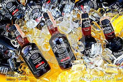 Many Cold Black whiskey mix with cola of Jack Daniel`s putting on ice in yellow tank for sale or party Editorial Stock Photo
