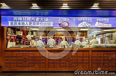 Group of cooks preparing famous Chongqing hot pot viewed from open window of a restaurant Editorial Stock Photo