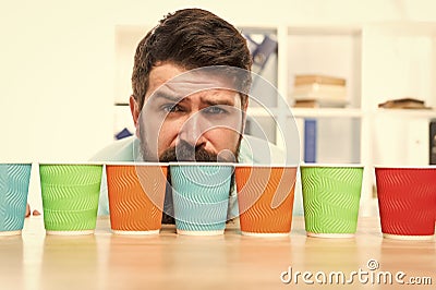 Choose from alternatives. Man bearded choosing one of lot colorful paper cups. Alternative concept. Pick one. Diversity Stock Photo